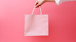 © Olha_B - Sale offer. Black Friday. Shopping discount. Closeup of woman hand holding purchase bags isolated on pink empty space background. concept of shopping, cyber monday. copy space for ad