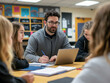 © tisomboon - A teacher leads a group of students in a collaborative classroom setting. The educator, wearing glasses and a gray jacket