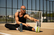 © svetlana_cherruty - Athlete stretching legs after workout, run or warming up front of sport stadium. Outdoors training. Water balance. Healthy and sport lifestyle concept.