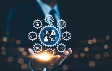 Wall Mural - b2c digital marketing, business strategy concept. businessman holding showing interconnected gears r