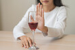 © KMPZZZ - Alcoholism, depressed asian young woman hand refuse red wine or alcoholic beverage, female drinking whiskey and quit booze. Treatment of alcohol addiction, having suffered abuse problem alcoholism.