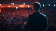 © fadi - Rear view of people in audience at the conference hall, Speaker giving a talk in conference hall at business event.