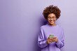 © best stock - Smiling young black woman girl in purple shirt posing isolated on purple wall background studio portait.