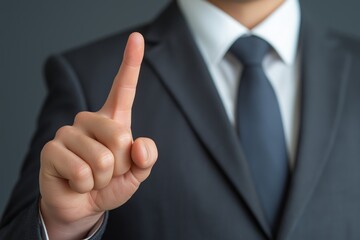 Businessman in suit point finger at camera in front of black background.