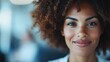 © Maximages  - A close-up of a smiling woman with curly hair, exuding positivity and friendliness. The vibrant expression reflects joy and an approachable demeanor.