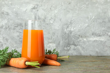 Wall Mural - Fresh carrot juice in glass and vegetables on textured table. Space for text