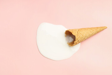 Wall Mural - Melted ice cream and wafer cone on light pink background, top view. Space for text