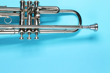 Wall Mural - One trumpet on light blue background, top view. Space for text