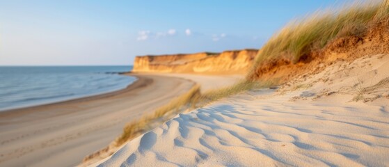  A sandy beach adjacent to the ocean, featuring a cliff on one side and another sandy beach on the other