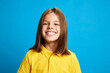 © master1305 - Happiness, joy and carefree. Portrait of young 9 years old girl in yellow polo shirt posing with big smile against blue studio background. Concept of childhood, kids emotions, lifestyle