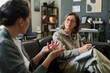© Mediaphotos - Two women sitting on couch discussing treatment plan during counseling session in cozy office environment with papers and pen in hand
