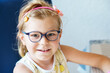 © Irina Schmidt - Portrait of a cute preschool girl with eye glasses indoors. Happy funny child wearing new blue glasses.