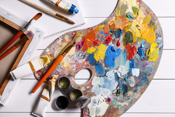 Sticker - Artist's palette, brushes, paints and blank canvases on white wooden table, flat lay