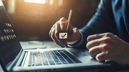 A man is typing on a laptop with a check mark on it