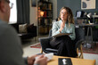 © Mediaphotos - Female therapist sitting in modern office, engaging with male patient and making notes on clipboard, creating comfortable atmosphere for conversation and counseling session