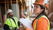 © fivan - A female construction worker supervising a team, holding a clipboard and pointing at construction plans