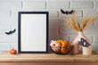 © maglara - Poster frame mock up for Halloween holiday. Wheat in modern vase and pumpkin decoration on wooden table over brick wall background