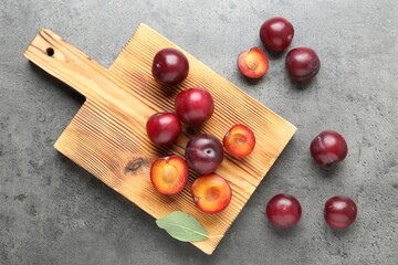 Wall Mural - Fresh plums on grey textured table, flat lay