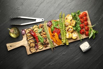 Wall Mural - Delicious grilled vegetables and spices served on grey textured table, flat lay