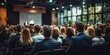 © Jack - Rear view of people in audience at the conference hall, Speaker giving a talk in conference hall at business event