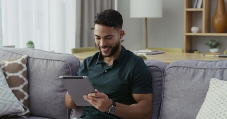 Poster - Happy, relaxed and carefree man with a tablet, browsing social media and surfing the internet at home. A cheerful and smiling guy reading news and posting online while sitting on living room sofa