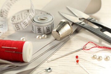 Poster - Different sewing tools on white wooden table, closeup