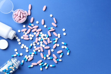 Wall Mural - Pharmacist concept. Many different pills on blue background, flat lay. Space for text