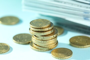 Wall Mural - Stack of euro coins on light blue background, closeup