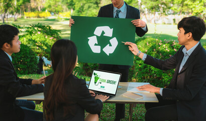 Group of businesspeople meeting at outdoor office in the nature planning and brainstorming on recycle strategy for greener environment by reducing and reusing recyclable waste. Gyre