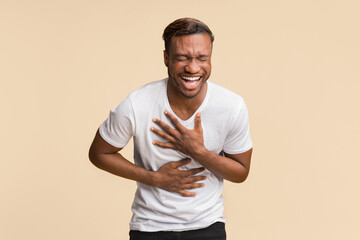 Sticker - LOL. Black Man Laughing Out Loud Pressing Hands To Chest Standing Over Yellow Background. Studio Shot