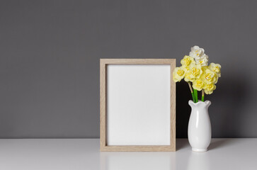 Wall Mural - Blank wooden photo frame mockup with flowers, blank frame with copy space over grey wall