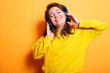 © DC Studio - Portrait of smiling happy person dancing to music with modern headphones. Enthusiastic woman with a smile wearing a headset to listen to music and audio for entertainment.