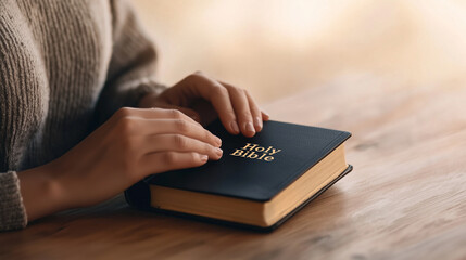 Wall Mural - Close-up of a woman's hands gently holding a closed book with the text 