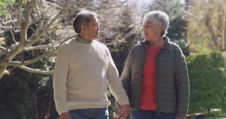 Canvas Print - Happy senior couple enjoying retirement outdoors in a green park or garden together. Healthy, in love and calm retired pensioner, man and woman walking holding hands with nature copy space background