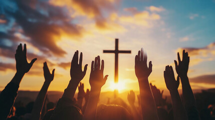 Hands raised in worship in front of a cross at sunset