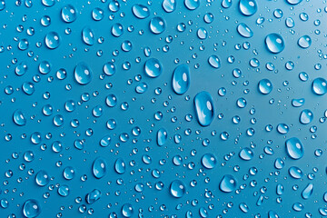 Water drops on blue background. Rain drops on glossy window glass.