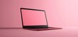 © ruslee - A sleek, modern laptop in a vibrant pink color with a blank screen, set against a matching pink background in a minimalist style.