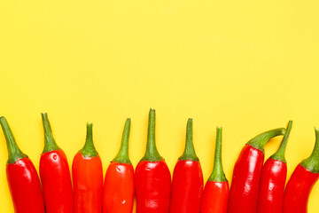 Wall Mural - Fresh hot chili peppers on yellow background