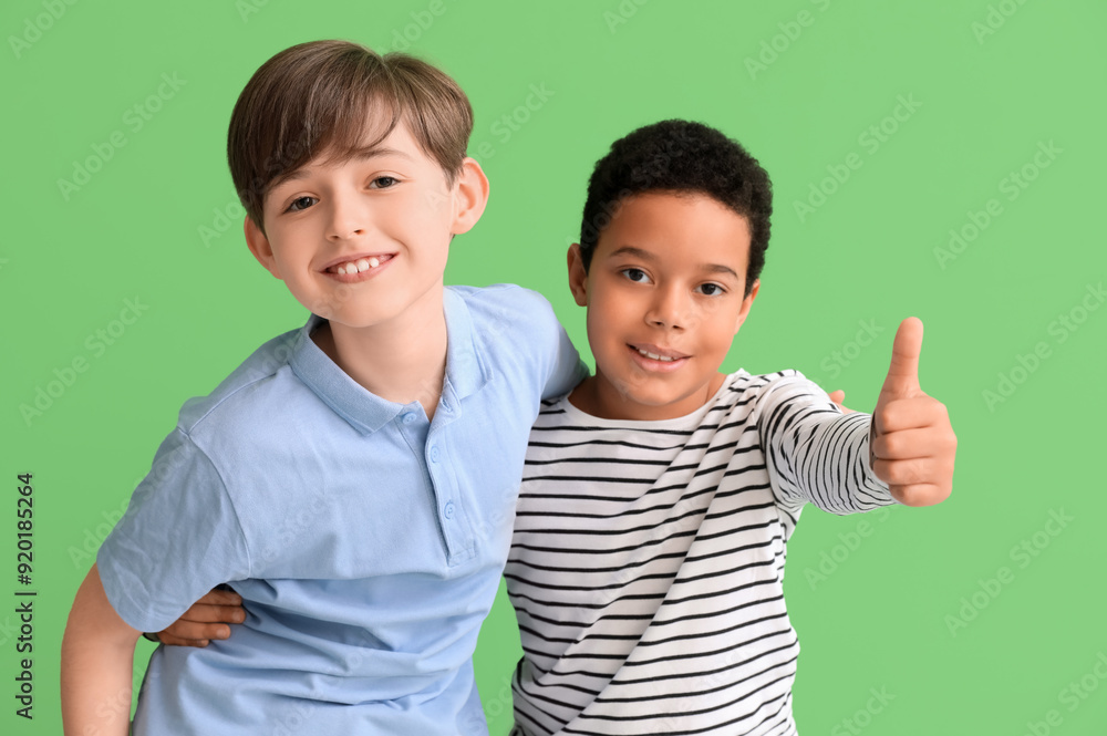 Cute little boys hugging on green background