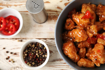 Sticker - Tasty sweet and sour chicken in bowl with spices on light wooden background, closeup