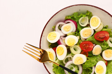 Wall Mural - Tasty salad with quail eggs, tomatoes, onion and lettuce on light background, closeup