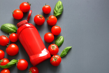 Wall Mural - Bottle of ketchup and tomatoes on grey background