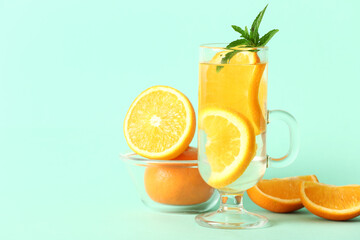 Wall Mural - Glass of infused water with orange slices on blue background