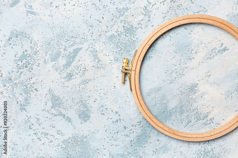 Wooden embroidery hoop on grunge blue background