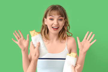 Wall Mural - Young woman and hands with tasty sandwich wraps on green background