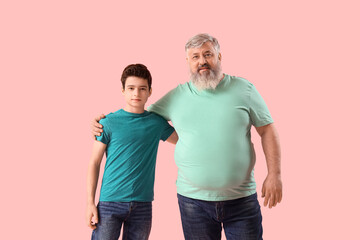 Wall Mural - Happy grandfather with his cute grandson on pink background