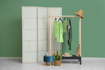 Sticker - Rack with female clothes near green wall