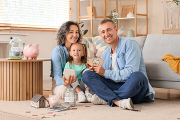 Canvas Print - Happy family with calculator, piggy banks and money jars sitting on floor at home