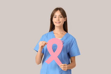 Sticker - Female doctor with pink ribbon on light background. Breast cancer awareness concept