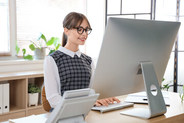 Canvas Print - Beautiful young businesswoman working with modern computer at table in office